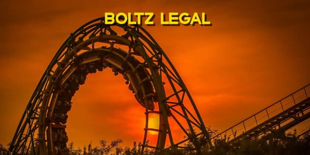 Roller coaster looping at sunset with bold orange sky, symbolizing theme park thrills and Epic Universe legal concerns